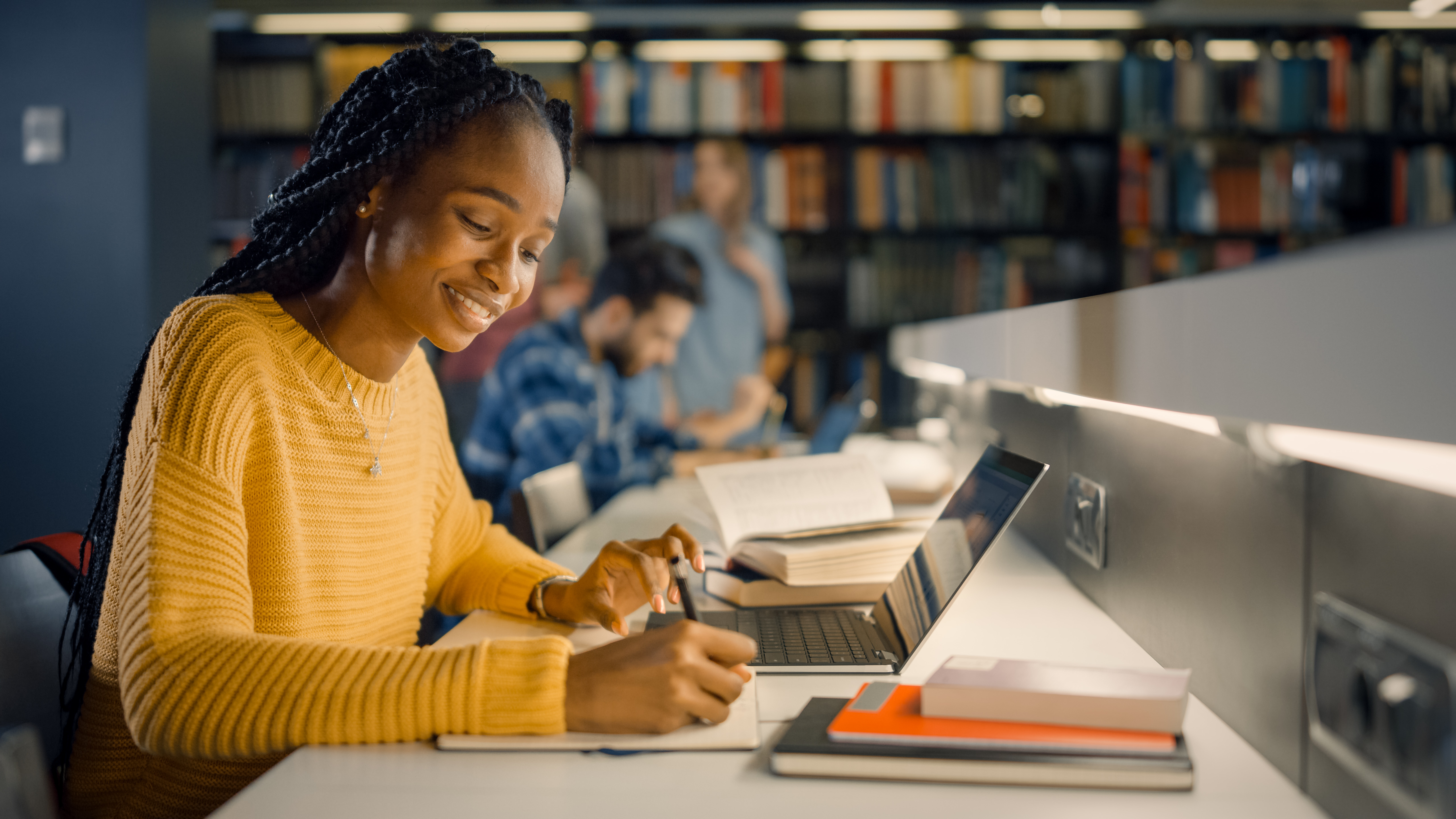 Young woman studying on laptop in library